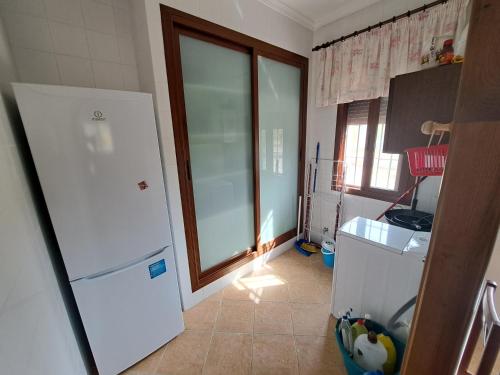 cocina con nevera blanca y ventana en Casa Rural en Monda en Málaga