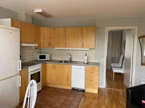 a small kitchen with wooden cabinets and white appliances at Vadstena centrum in Vadstena
