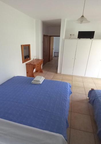 a bedroom with a blue bed and a desk at Glaros Studios in Loutra Edipsou