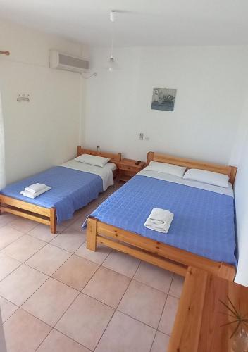 two beds in a room with blue sheets at Glaros Studios in Loutra Edipsou