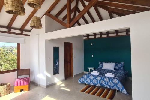 a bedroom with a bed and a green wall at Villa RenaSer in Villa de Leyva