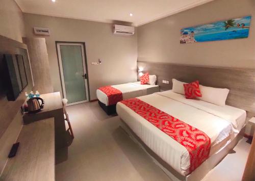 een hotelkamer met 2 bedden en een televisie bij Lavigo Resort in Pantai Cenang