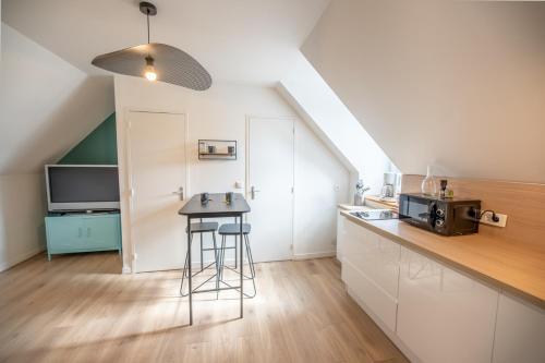 une cuisine avec un comptoir et un tabouret dans une pièce dans l'établissement LE ARA - Gare - centre ville - By Nid'Ouest, à Quimper