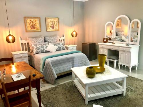 sypialnia z łóżkiem, stołem i biurkiem w obiekcie Rooibos Retreat w mieście Richards Bay