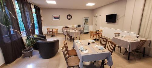 - un restaurant avec des tables et des chaises dans une salle dans l'établissement L'Orée du Bois, à Ergué-Gabéric