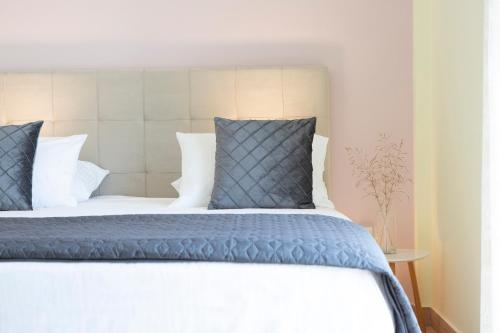 a bed with blue and white sheets and pillows at Sea n' Smile in Apolpaina