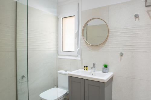 a bathroom with a toilet and a sink and a mirror at Sea n' Smile in Apolpaina