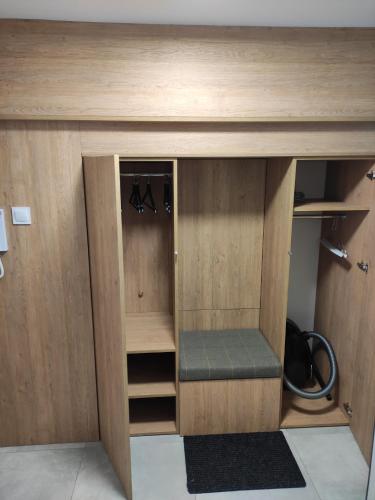 a wooden cabinet with a bench under a desk at Apartament AirPort in Wrocław