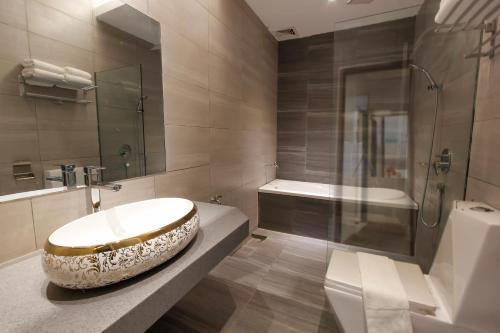 a bathroom with a bowl sink and a bath tub at Lavigo Resort in Pantai Cenang