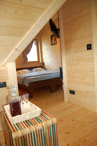 a room with a bed in a wooden cabin at Willa Tritri 1 Butikowy dom wakacyjny in Witów