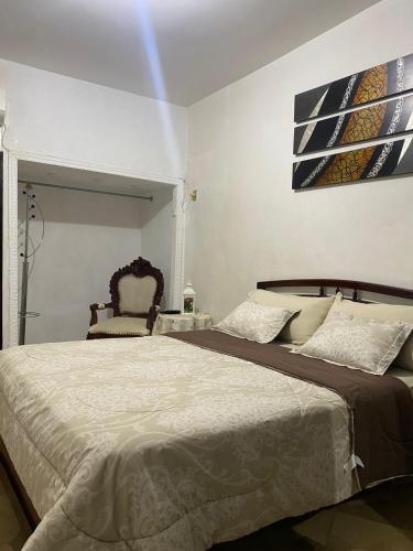 - une chambre avec un grand lit et une chaise dans l'établissement Departamento amoblado centro Manta, à Manta