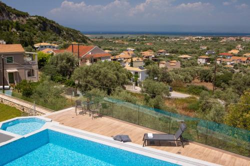 a villa with a swimming pool and a house at Sea n' Smile in Apolpaina
