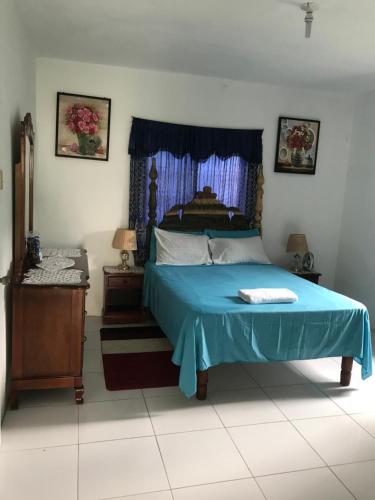 a bedroom with a bed with a blue comforter at June’s comfort paradise in Runaway Bay