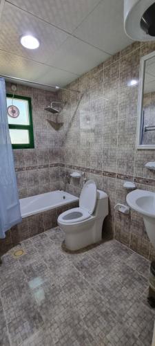 La salle de bains est pourvue de toilettes, d'une baignoire et d'un lavabo. dans l'établissement ALMajd Hotel, à Ibri