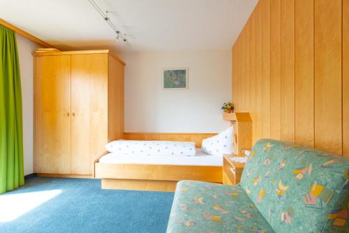 a small room with a bed and a couch at Haus Furka in Damuls