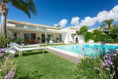 une villa avec une piscine et une maison dans l'établissement paradise island, à Marina di Ragusa