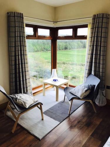 a living room with two chairs and a large window at Coby's Corner, Darney Rd Bruckless in Bruckless
