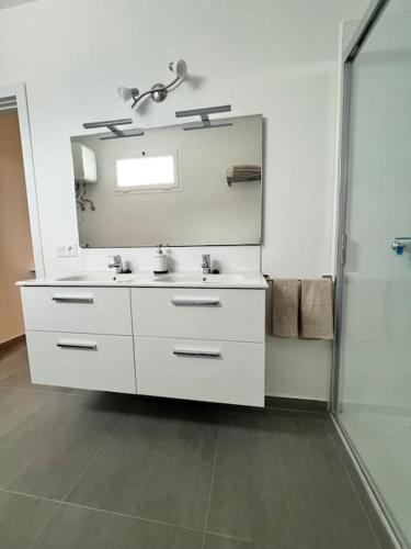 a white bathroom with a sink and a mirror at El Cercado in Tinajo