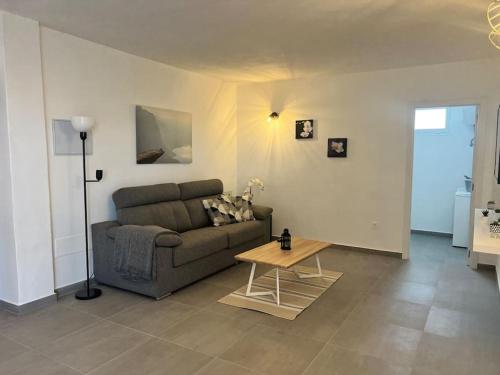 ein Wohnzimmer mit einem Sofa und einem Tisch in der Unterkunft El Cercado in Tinajo
