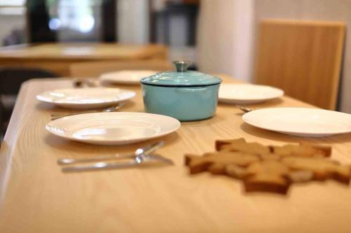 a wooden table with white plates and a blue container at 619Villa in Tainan