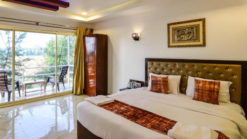 una camera con un grande letto e un balcone di Arabian Sea Beach Resort a Morjim