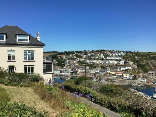 a house on a hill next to a body of water at Honeycombe House in Mevagissey