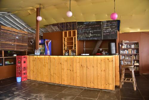 a restaurant with a wooden counter and a chalkboard at Jardim a Mar in Agonda