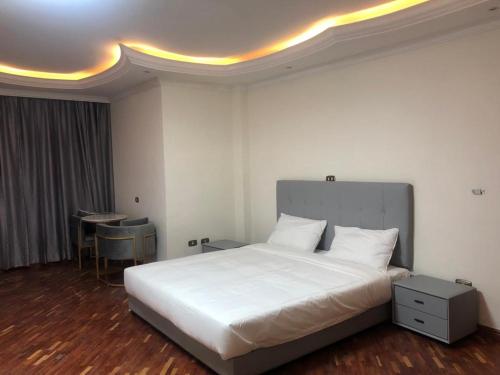a bedroom with a large white bed and a table at Social House in Addis Ababa