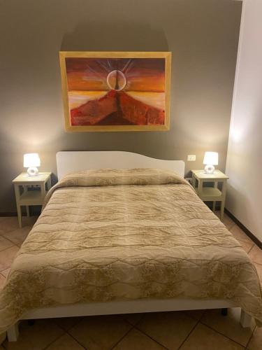 een slaapkamer met een bed en 2 nachtkastjes bij La Casa di Mimì in Foligno