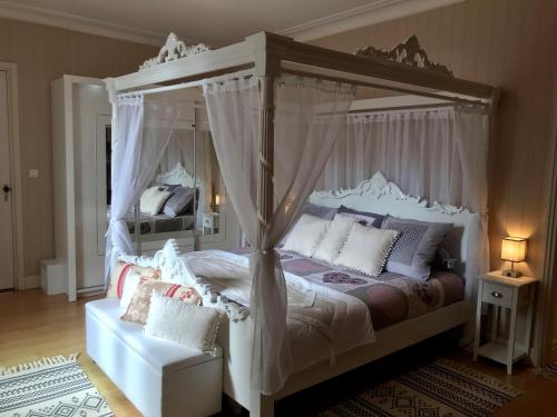 Loupiac-de-Cadillac的住宿－les trois tilleuls，卧室配有带枕头的白色天蓬床