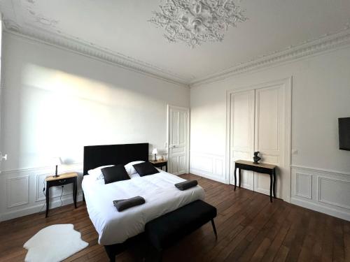 - une chambre avec un grand lit blanc et un plafond dans l'établissement l'Hôtel des Ventes Reims Chativesle, à Reims
