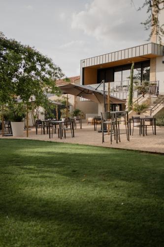 a group of tables and chairs in front of a building at Hôtel-Restaurant Villa Métis in Les Herbiers