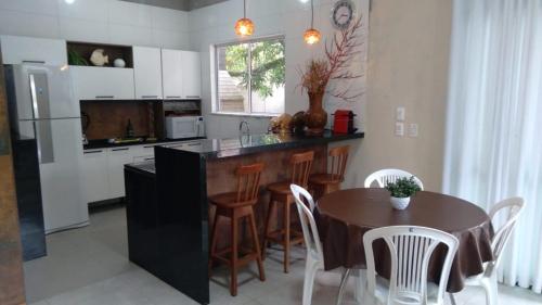 cocina con mesa y sillas y cocina con nevera en Morada das Águas Campinho Maraú BA, en Maraú
