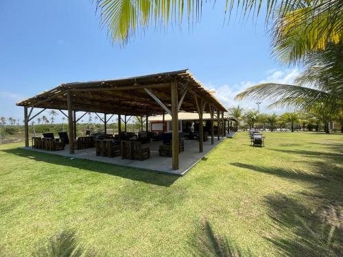 a picnic shelter in a park with a palm tree at Apartamento standart premium aconchegante in Subaúma