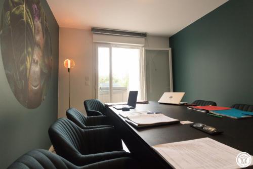 an office with a long desk with chairs and a window at Villa "La Recrée Toulousaine " Clim & SPA-12 couchages in Cugnaux
