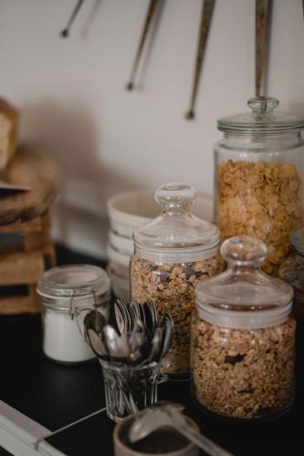a group of jars filled with food on a counter at Hôtel-Restaurant Villa Métis in Les Herbiers