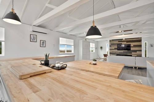 ジョシュア・ツリーにあるBeautiful newly remodeled home, near JT Parkの木製テーブルが備わる白い広い客室です。