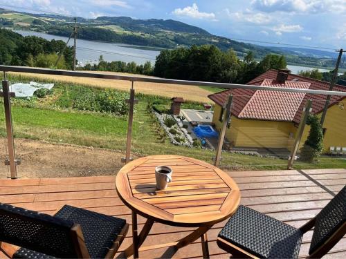 a wooden table and chairs on a wooden deck at Wichrowe Wzgórze z jacuzzi in Znamirowice