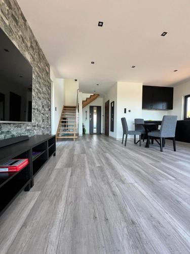 a living room with a table and a dining room at Wichrowe Wzgórze z jacuzzi in Znamirowice