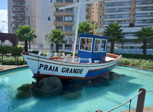 a boat sitting in a pool of water at Apê Temporada Vila Guilhermina in Praia Grande