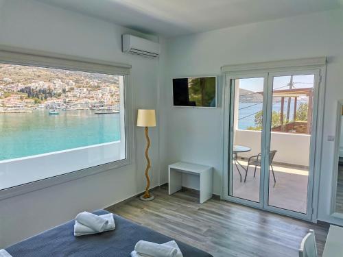 a bedroom with a large window with a view of the water at Galazio Rooms & Suites in Batsi