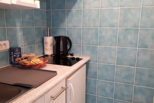 Il comprend une cuisine dotée de murs en carrelage bleu et d'un four avec plaques de cuisson. dans l'établissement Studio at -La Croisette- Cannes - BEACH GARDEN -, à Cannes