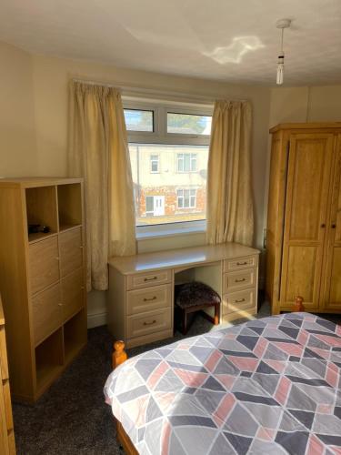 a bedroom with a desk and a bed and a window at Spacious 9 bed house in Mansfield Nottinghamshire in Mansfield