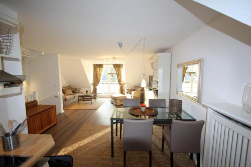 a living room and dining room with a table and chairs at Appartement Nordseesonne in Wenningstedt