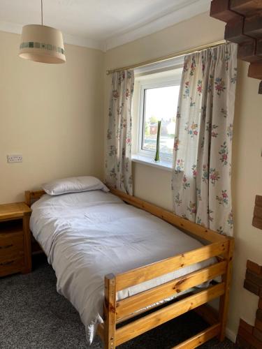 a bedroom with a bed and a window with curtains at Spacious, Sleeps 17, 3 bathrooms, Parking, Mansfield in Mansfield