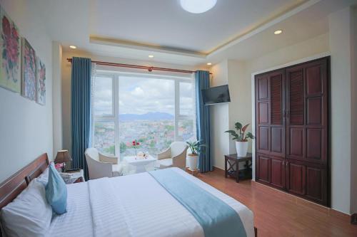 een slaapkamer met een groot bed en een groot raam bij Rose Valley Hotel Da Lat Vietnam in Da Lat