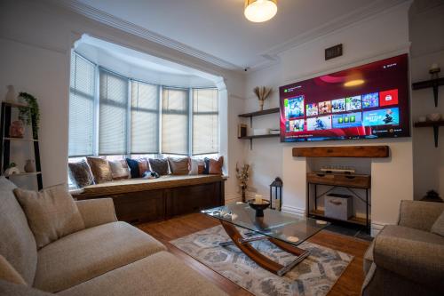 uma sala de estar com um sofá e uma televisão de ecrã grande em Cavendish Cat and Gaming House em Blackpool