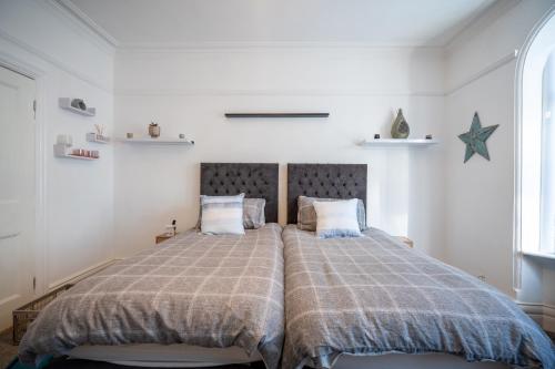 a bedroom with a large bed with a blanket at Cavendish Cat and Gaming House in Blackpool