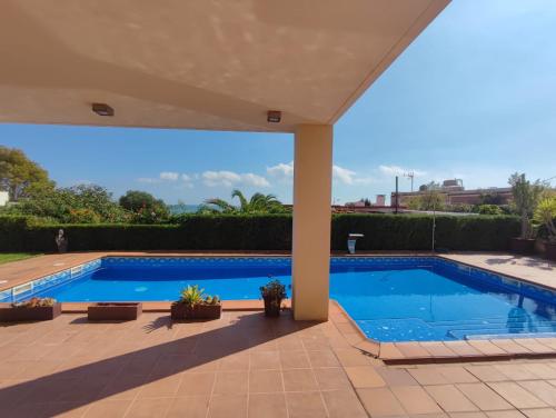 a large swimming pool in a yard with a patio at VILLA MARICEL in Alcanar