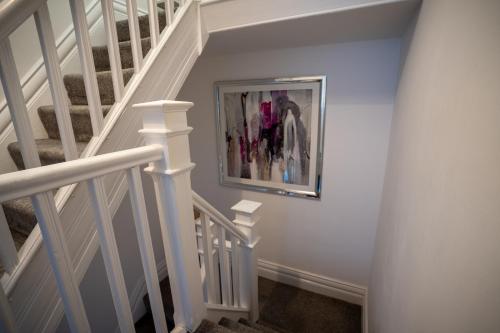 a staircase with a painting on the wall at Cavendish Cat and Gaming House in Blackpool